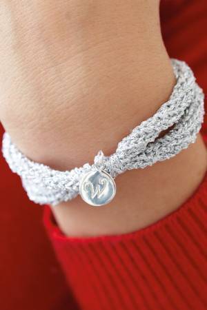 Silver knitted bracelet with charm attached 