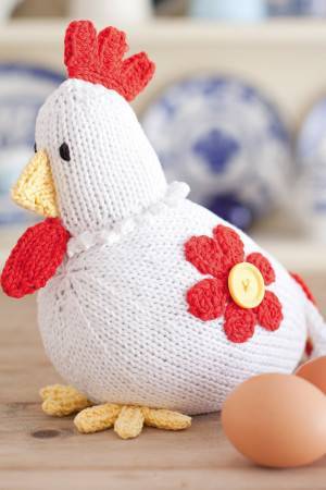 Knitted chicken with bright red comb on head and flower motif