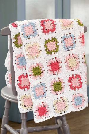 Crocheted granny square throw in pretty pastel colours