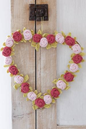 Crocheted heart shaped wreath with flowers and leaves