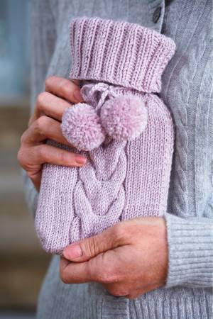Tiny knitted hot water bottle cover with cable, pom-poms and deep cuff