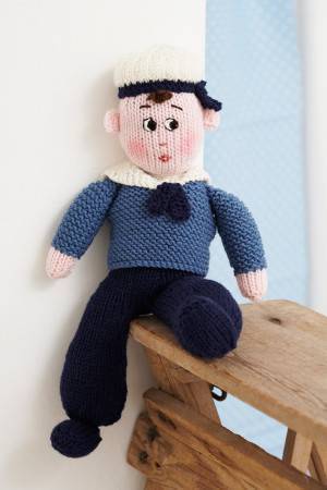 Knitted sailor in traditional uniform with cute cap and embroidered face