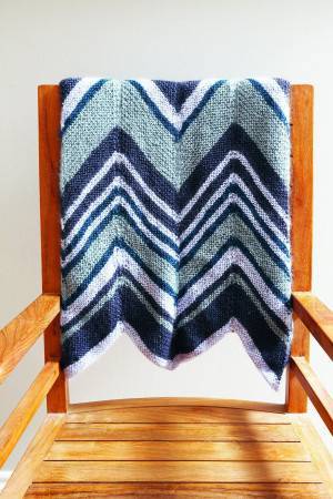 Bold knitted zig zag pattern blanket with deep V design in shades of blue